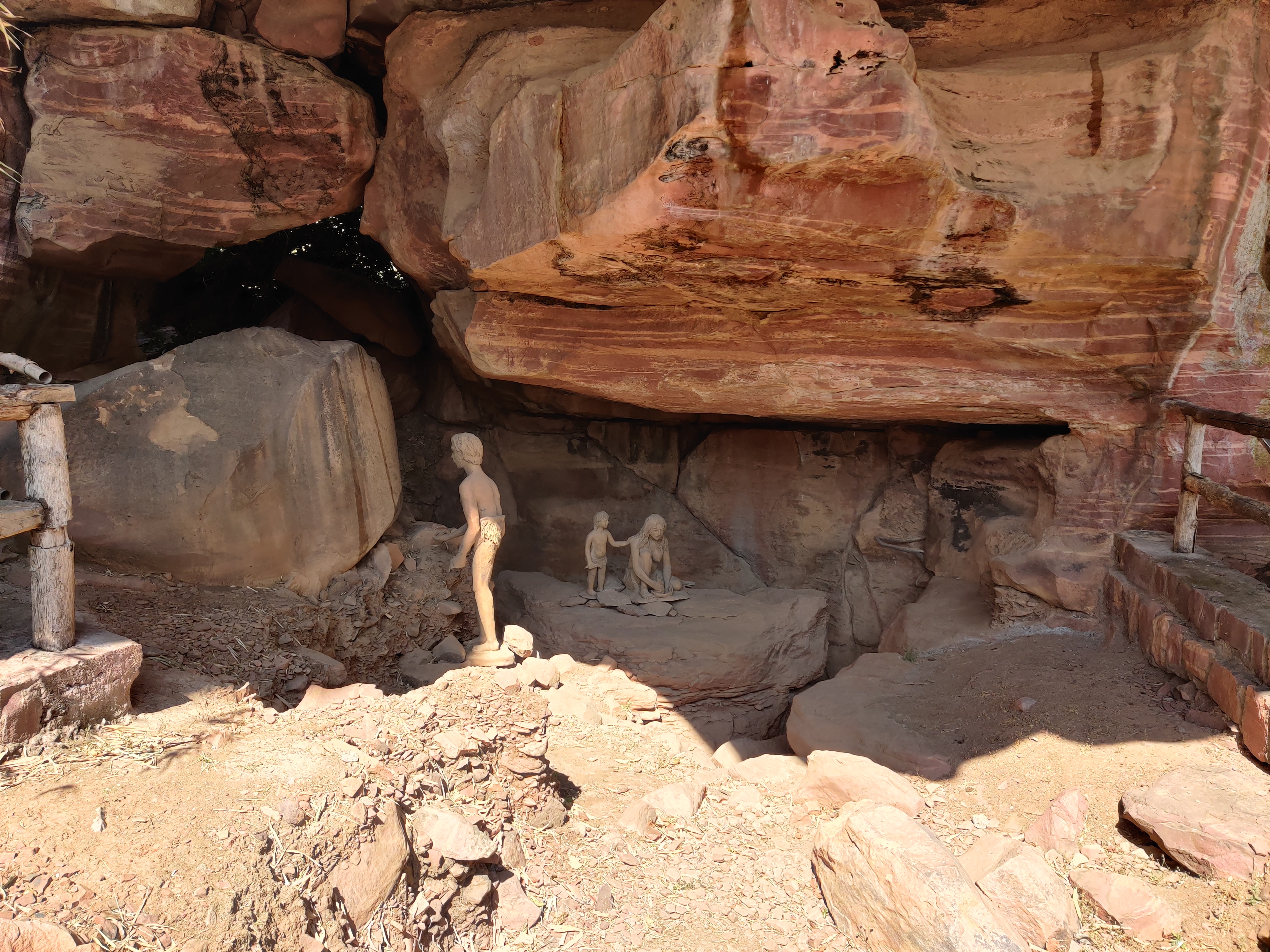 Picture of Bhimbetika cave enterance with statues of children playing.